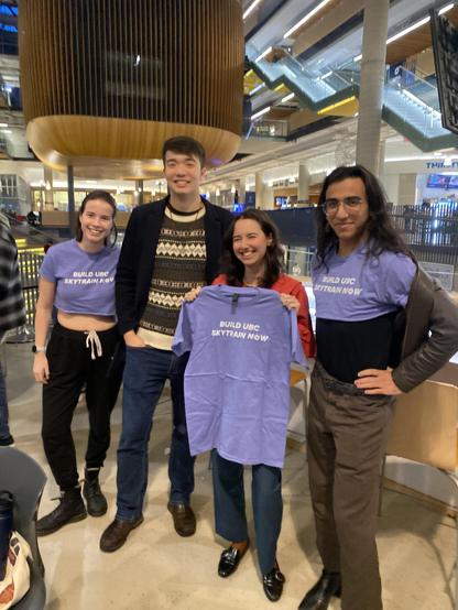 Emily Lowan with young greens and supporters at UBC campus - with a shirt that says "Build UBC skytrain now"