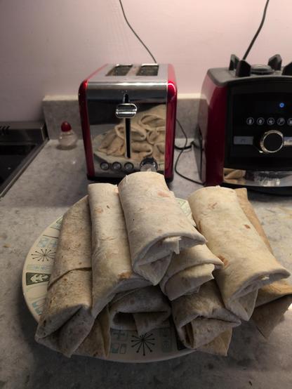 A plate with a stack of burtitos