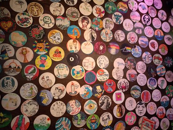 A wall full of dozens of hand drawn paper drink coasters, no I'm not going to describe them all, sorry