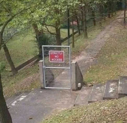 A short gate with the sign "Strictly No Access" blocking a paved path, but you can easily walk around it and continue on the path.