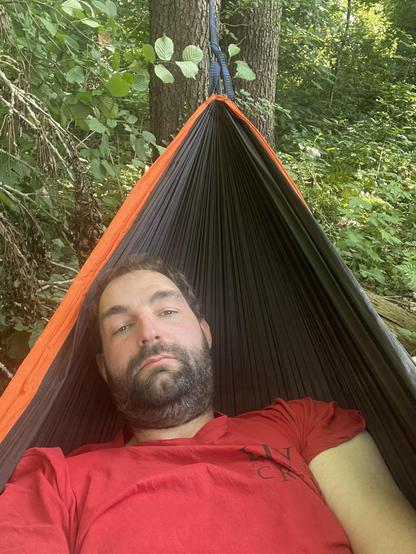 Ein Foto von mir in einer Hängematte, ich trage ein rotes T-Shirt.