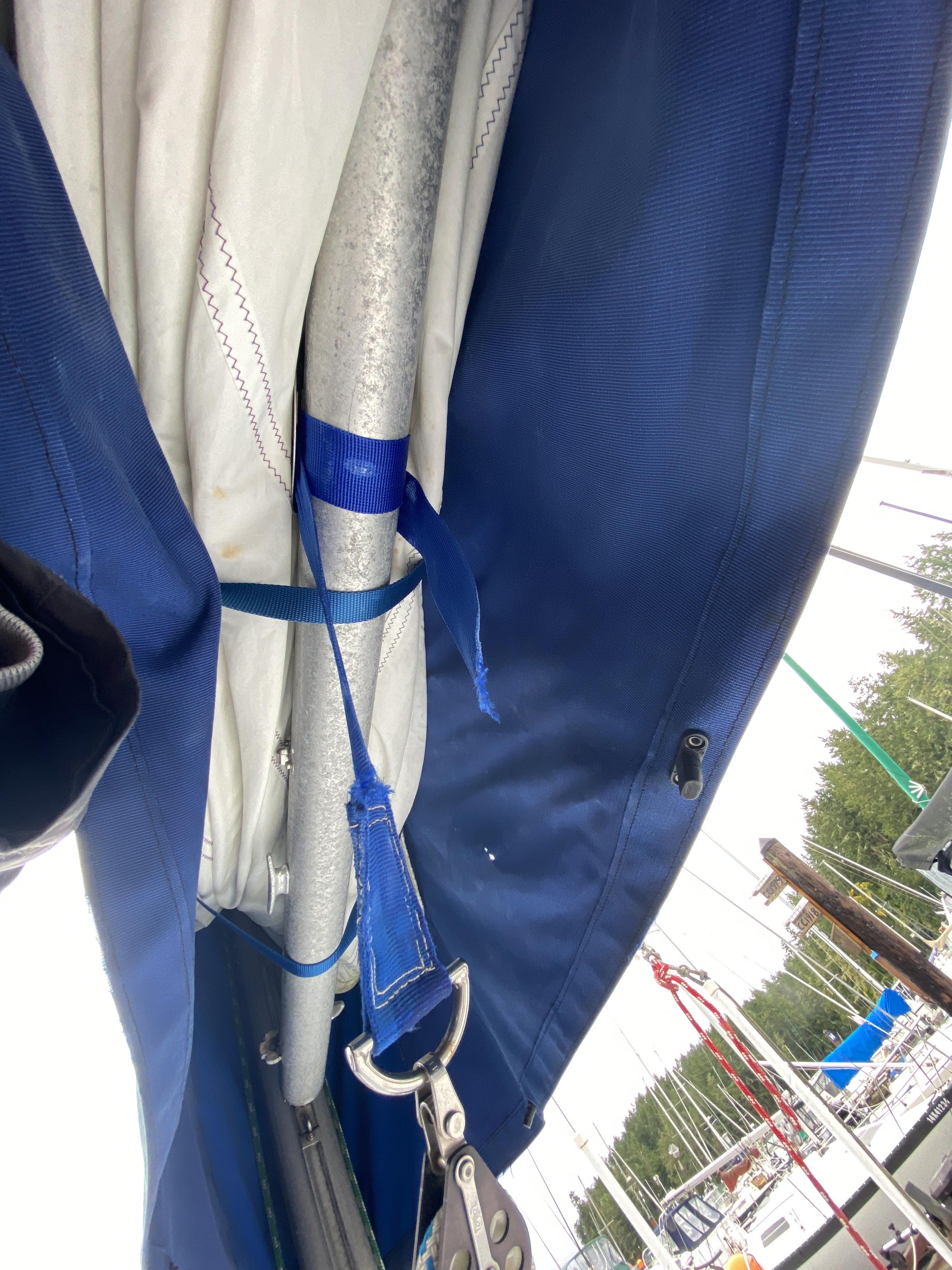 A view from below, looking up, showing how the blue strap feeds underneath the boom between the two clips.
