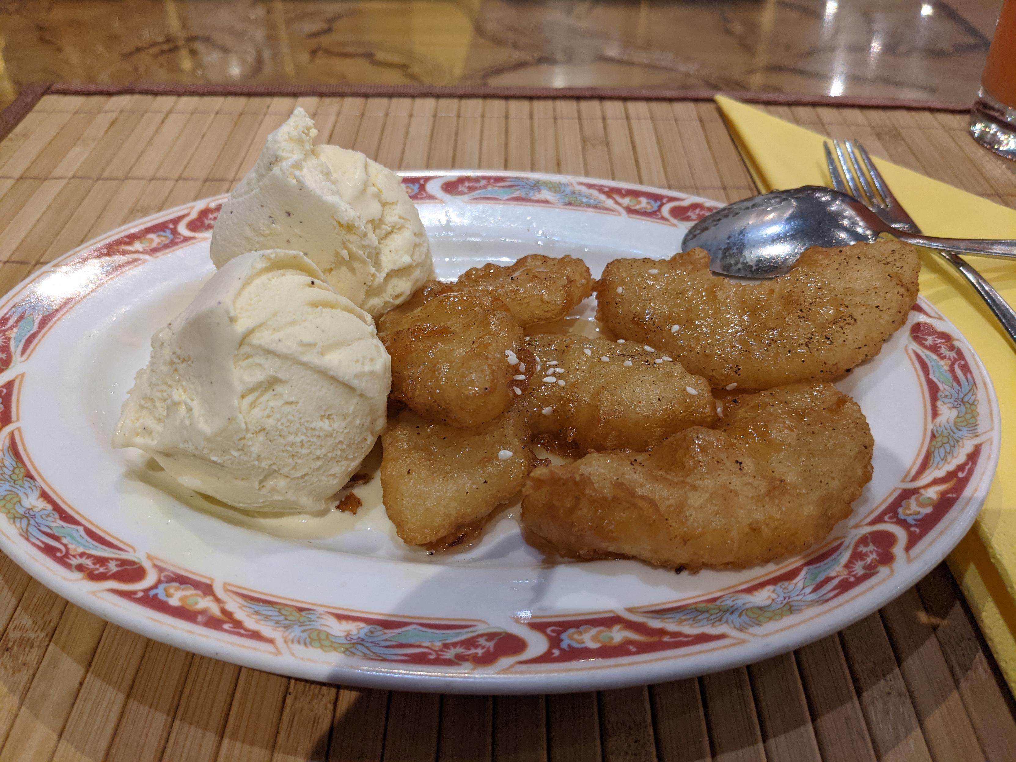 A plate of fried pineapple with vanilla ice cream