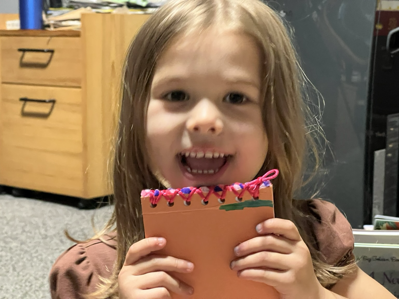 Young girl smiling holding her custom bound sketchbook