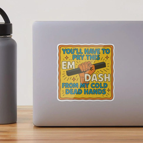 A sticker on a laptop, which reads "You'll have to pry this Em-Dash from my cold dead hands."